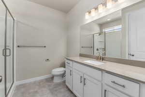 Bathroom with vanity, toilet, and a shower with door