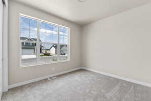 Carpeted spare room featuring a wealth of natural light