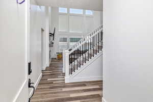 Stairway with hardwood / wood-style flooring, a high ceiling, and plenty of natural light