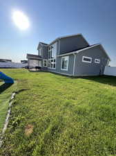 Back of house with a pergola and a yard