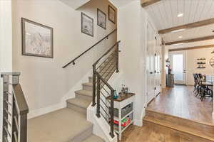 Stairway featuring beamed ceiling and hardwood / wood-style flooring