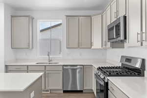 Kitchen with stainless steel appliances, gray cabinets, and sink