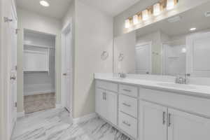 Bathroom with a shower with shower door and vanity