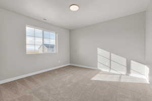 Empty room featuring light colored carpet