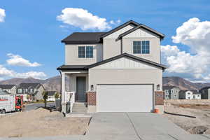 View of front of property with a mountain view and a garage