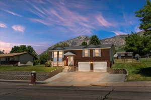 Bi-level home with a mountain view, a garage, and a yard