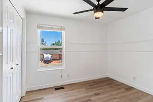 Unfurnished room featuring ceiling fan and light wood-type flooring