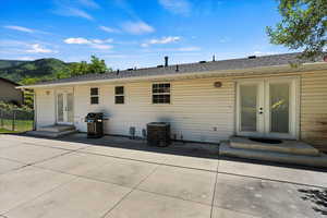 Rear view of property featuring cooling unit, a patio, and french doors