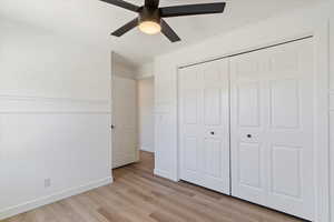 Unfurnished bedroom with ceiling fan, light hardwood / wood-style floors, and a closet