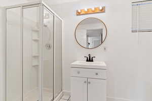 Bathroom with vanity, walk in shower, and tile patterned floors