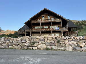 Rear view of property with a mountain view and a balcony