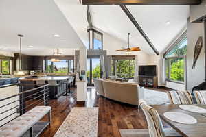 Living room with beamed ceiling, sink, high vaulted ceiling, dark hardwood / wood-style flooring, and ceiling fan