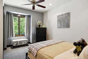 Carpeted bedroom with ceiling fan