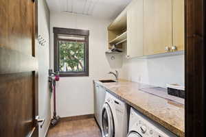 Laundry area with separate washer and dryer, cabinets, and sink