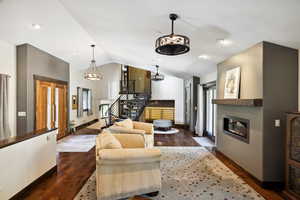 Living room featuring lofted ceiling and dark hardwood / wood-style flooring