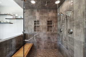 Bathroom featuring tile walls and a tile shower