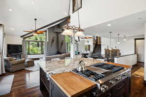 Kitchen featuring dark hardwood / wood-style floors, stainless steel gas stovetop, a center island, and ceiling fan