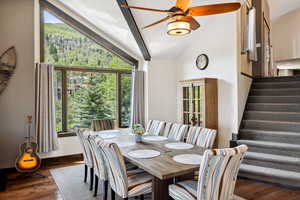 Dining area with vaulted ceiling, ceiling fan, and dark wood-type flooring