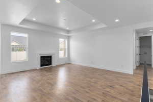 Unfurnished living room with a raised ceiling and hardwood / wood-style floors