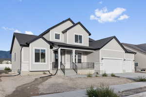 View of front of house with covered porch and a garage