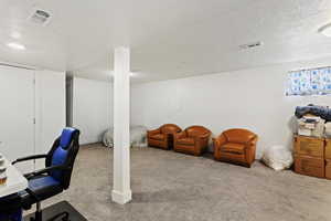 Carpeted office space featuring a textured ceiling