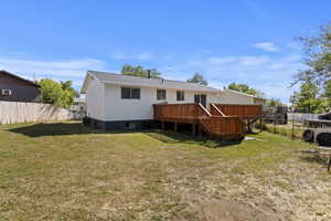 Back of property featuring a yard and a deck