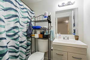 Bathroom with toilet, vanity, and a textured ceiling