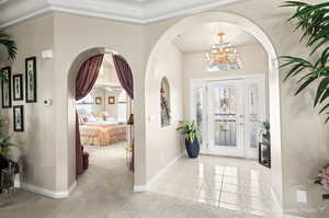 Tiled foyer with an inviting chandelier and plenty of natural light