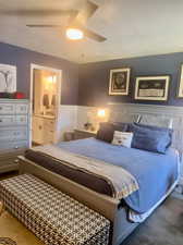 Carpeted bedroom featuring ensuite bathroom, a textured ceiling, and ceiling fan