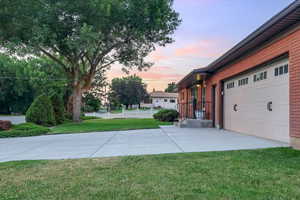 Yard at dusk featuring a garage