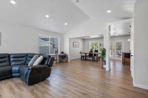 Living room with french doors, hardwood / wood-style flooring, and lofted ceiling