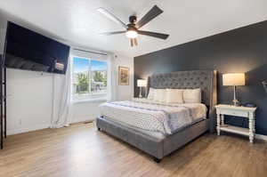 Bedroom featuring ceiling fan and hardwood / wood-style flooring