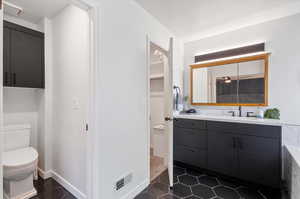 Bathroom featuring vanity, tile patterned flooring, and toilet