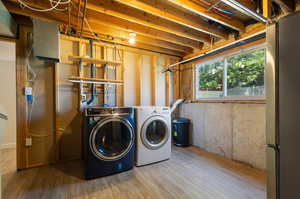 Laundry area featuring wood-type flooring and washer and dryer