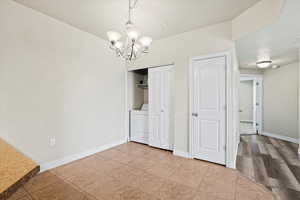 Interior space featuring washer / clothes dryer, a notable chandelier, and light hardwood / wood-style floors