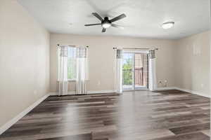 Spare room with dark hardwood / wood-style floors and ceiling fan