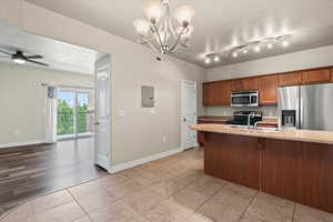 Kitchen featuring track lighting, appliances with stainless steel finishes, decorative light fixtures, and sink