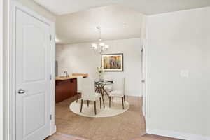 Digitally staged Dining area featuring wood-type flooring, sink, and a chandelier