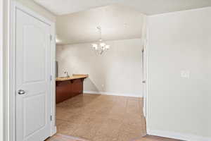 Dining area featuring sink, an inviting chandelier, and light tile patterned floors