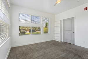 Carpeted spare room with ceiling fan