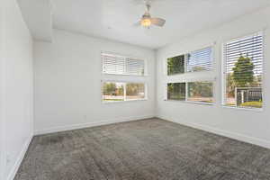 Carpeted empty room featuring ceiling fan