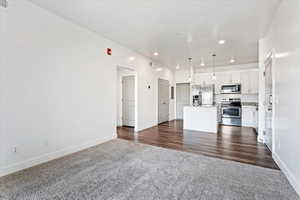 Unfurnished living room with dark wood-type flooring