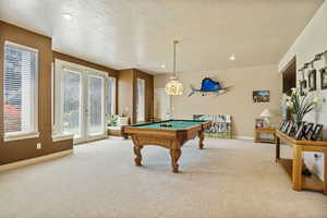 Playroom featuring a textured ceiling, carpet, and billiards