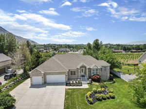 Single story home with a mountain view, a garage, and a front lawn