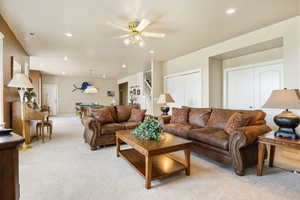 Living room with pool table, light colored carpet, and ceiling fan