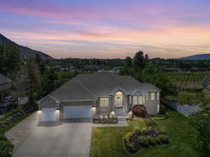 View of front of home featuring a garage, a yard, and a mountain view