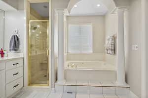 Bathroom with independent shower and bath, ornate columns, vanity, and tile patterned flooring