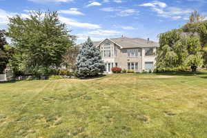 Rear view of house featuring a yard