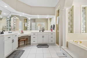 Bathroom with vanity, separate shower and tub, decorative columns, and tile patterned flooring