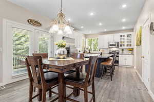 Dining space with a chandelier and light wood-type flooring